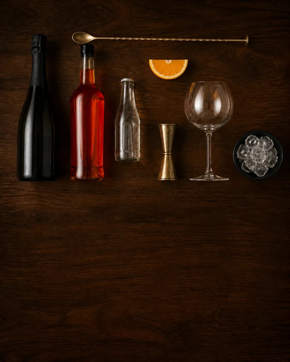 Overhead Aperol Spritz station arranged on a dark walnut bar
