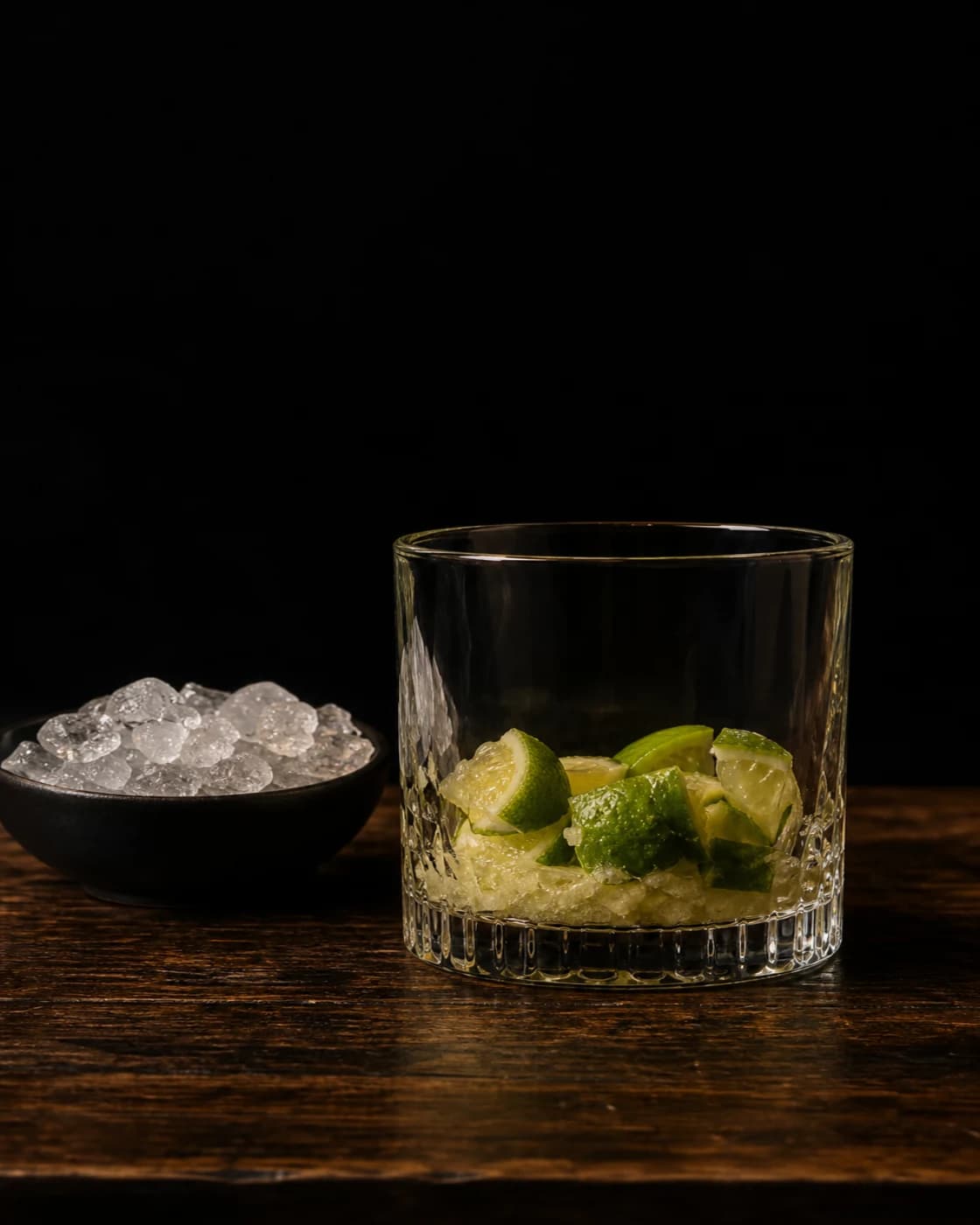 Add ice and cachaça stage with unbranded clear cachaça bottle