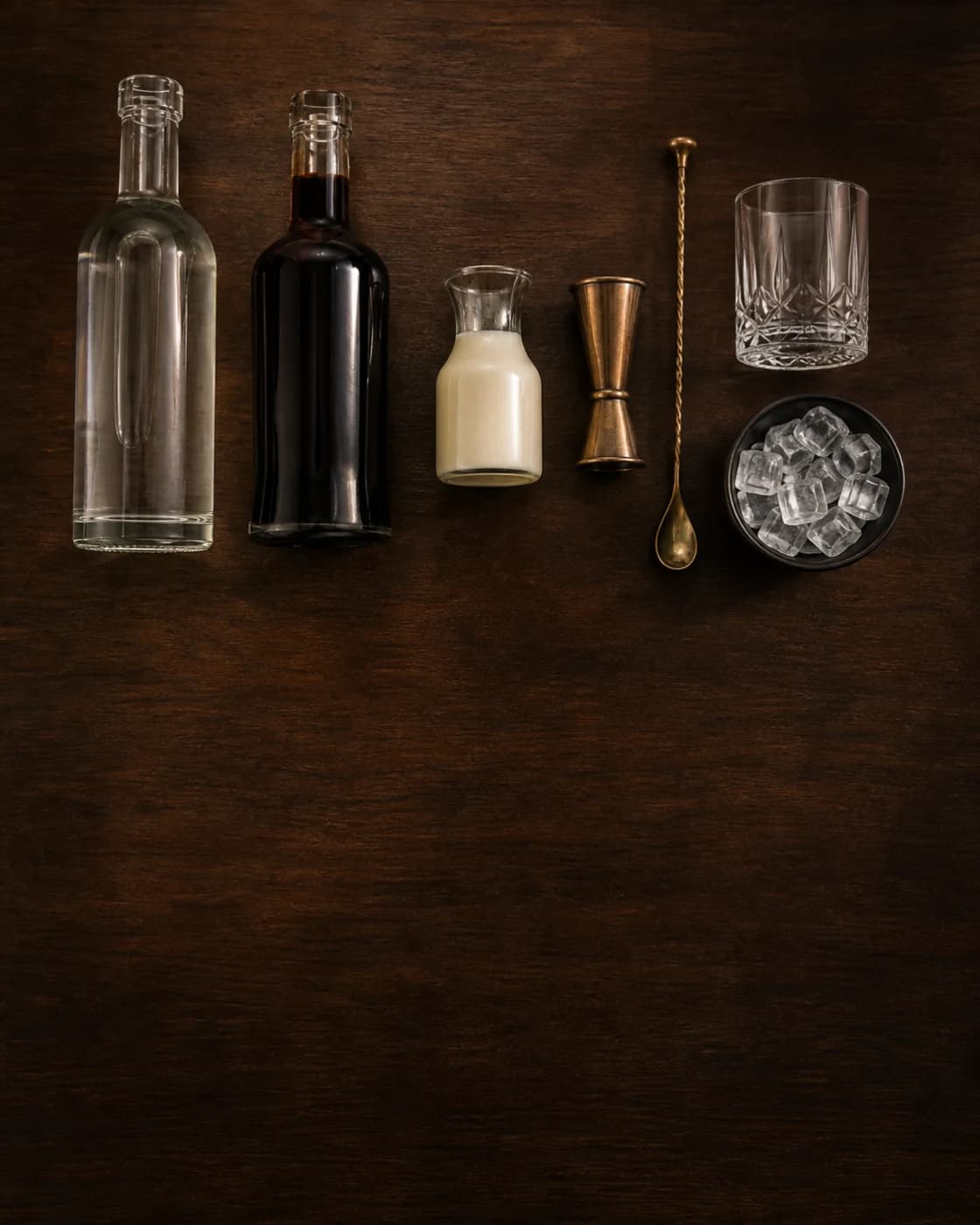 Overhead White Russian station arranged on a dark walnut bar