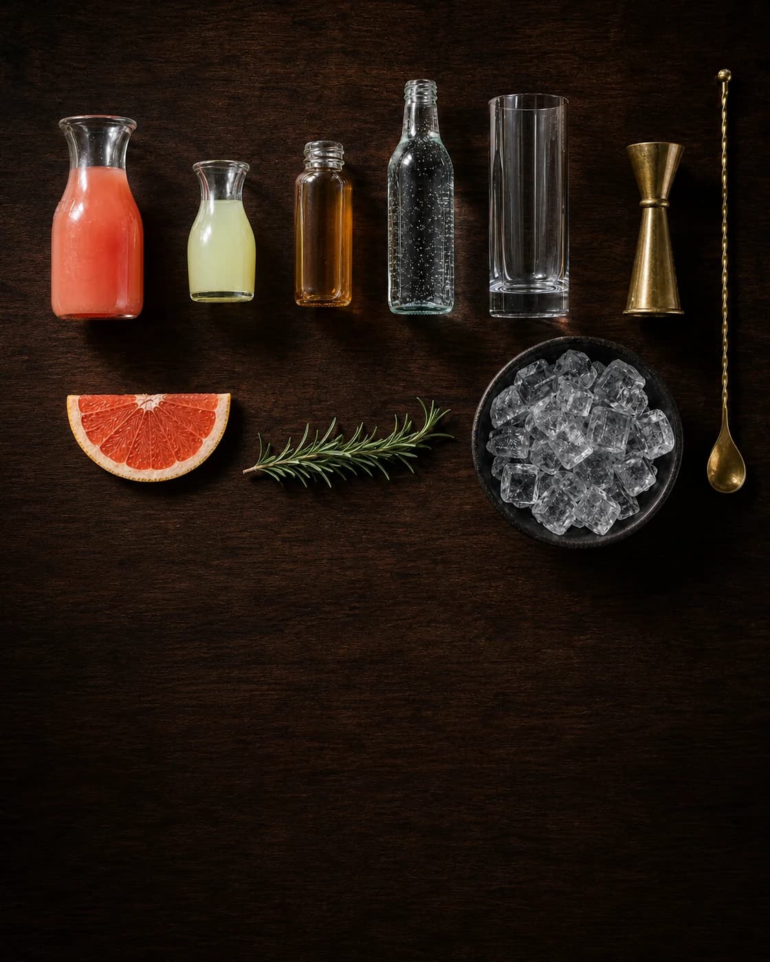 Overhead citrus highball station arranged on a dark walnut bar
